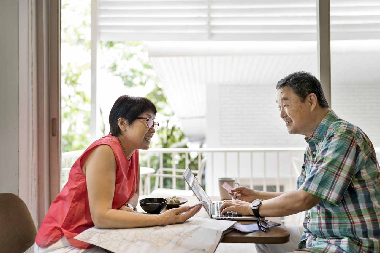 Senior asian couple using the laptop while talking