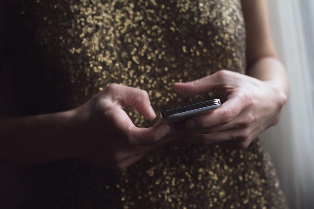 Close up of woman hands in party dress holding a phone