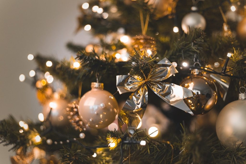 Shallow focus shot of beautiful baubles and string lights hanging on a Christmas tree