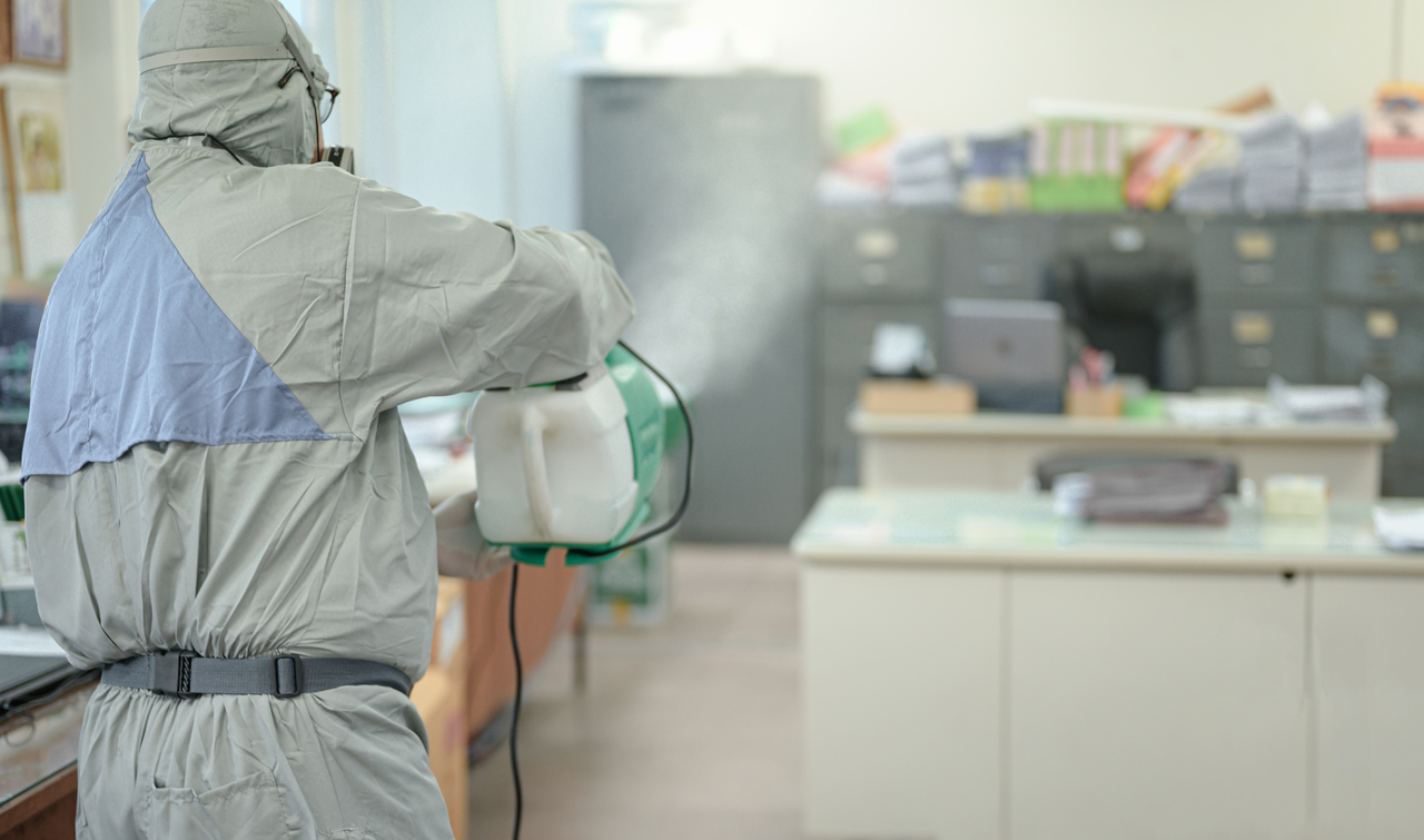 A man disinfecting an office