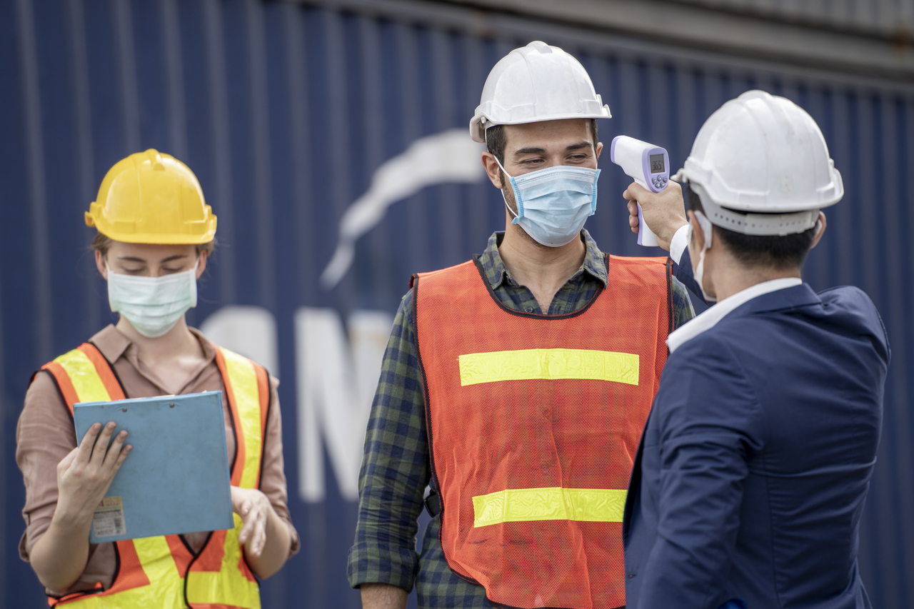 Industrial worker's temperature being checked