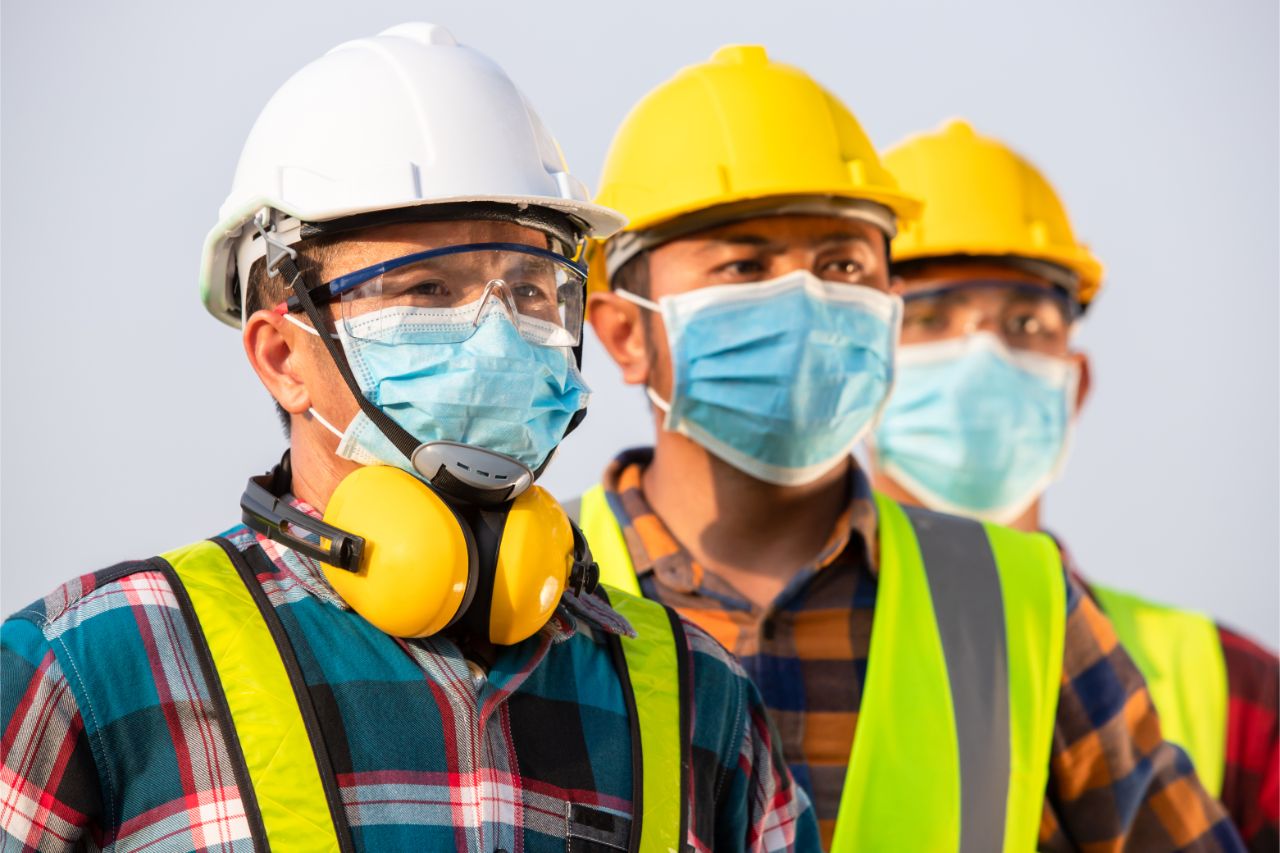 Manufacturing workers with face masks and personal protective equipment